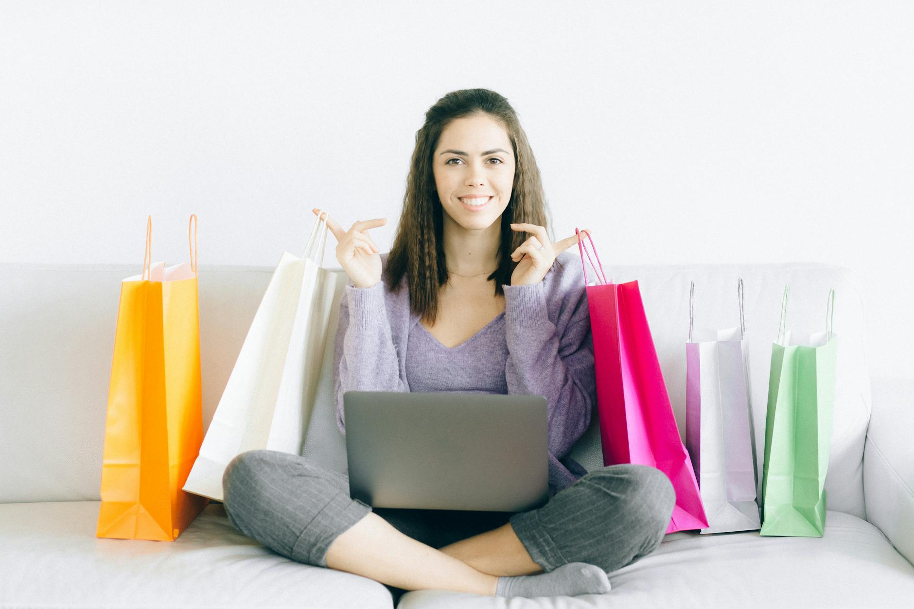 Make $100 a Day and shop at will - A woman on sofa holding shopping bags